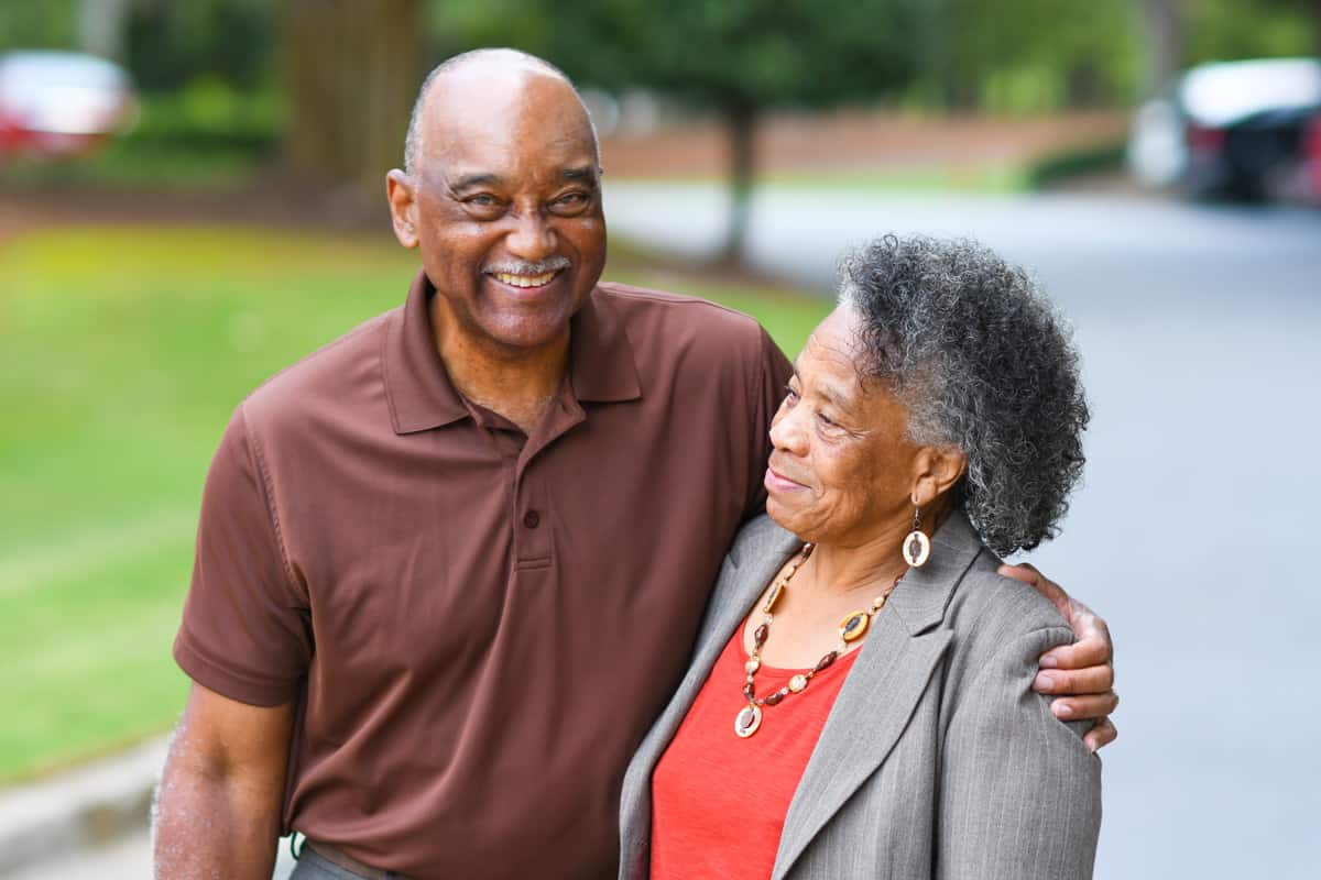 Senior couple living at Traditions of Medina enjoying a walk on the paved community walking paths